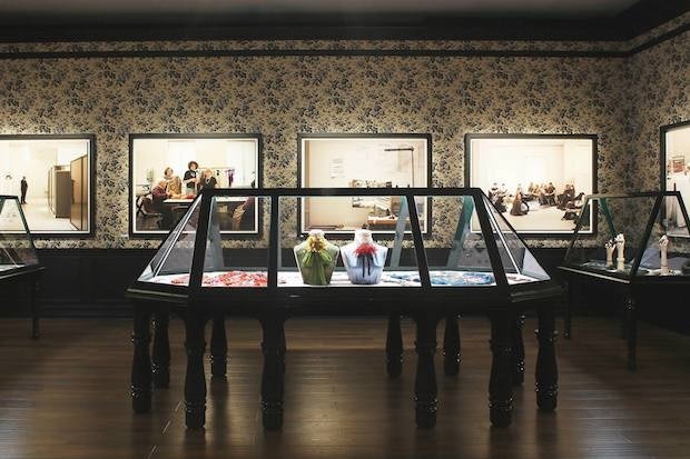 Gucci items on display with artwork at "No Longer / Not Yet." (Courtesy Photo)