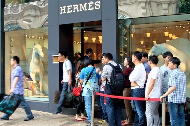 Chinese shoppers wait outside an Hermès store in Hong Kong. (Bon Brand)