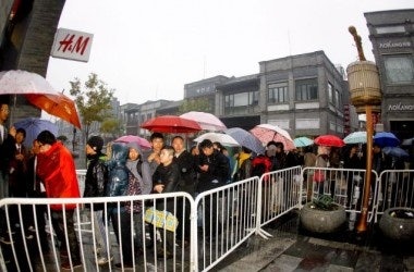 Customers line up in the rain for the release of the Versace for H&M collection in Beijing (Image: Metro UK)