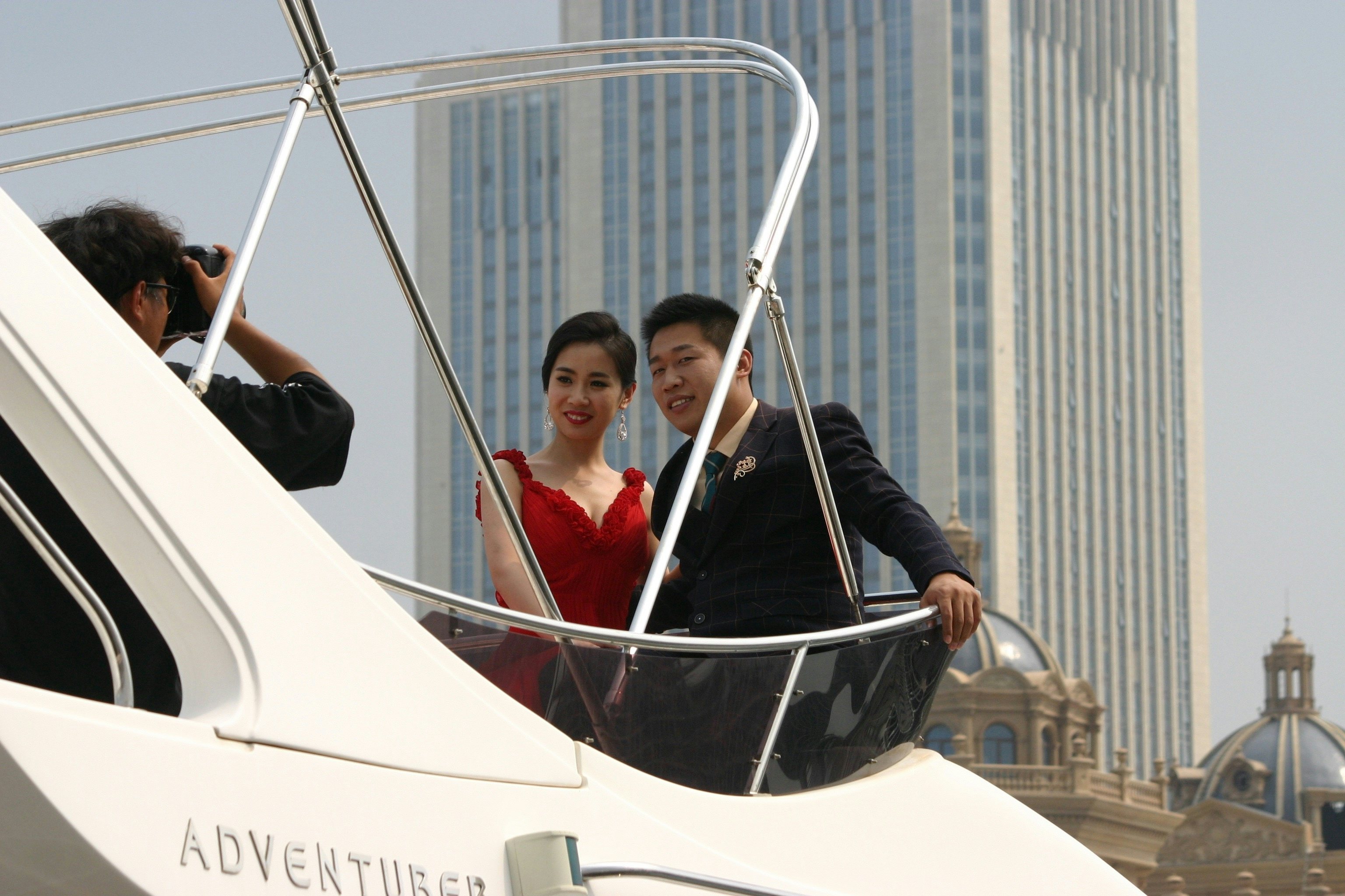 A Chinese couple poses for a photo onboard a yacht in Dalian, China. (Jing Daily)
