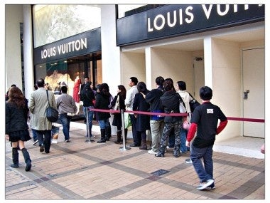 Chinese tourist-shoppers line up outside a Louis Vuitton store in Hong Kong