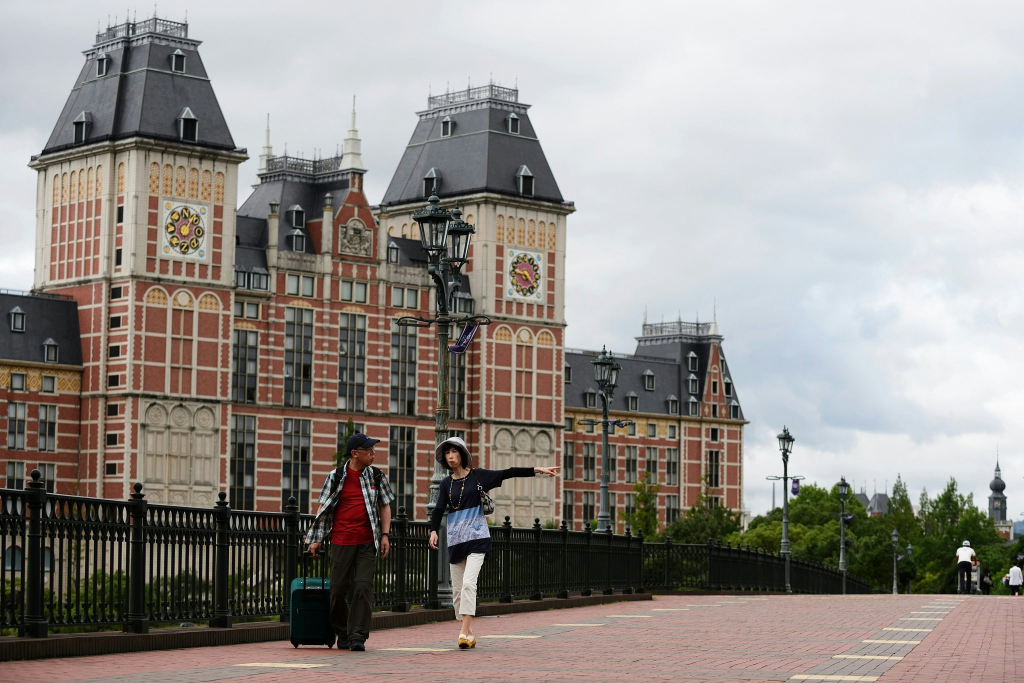 Visitors walk on a bridge at the Dutch-themed Huis Ten Bosch amusement park, operated by Huis Ten Bosch Co., in Sasebo, Nagasaki Prefecture, Japan, on Friday, July 17, 2015. Huis Ten Bosch is spread across 1.52 million square meters (376 acres), about twice the size of Tokyo Disneyland, according to its website. Photographer: Akio Kon/Bloomberg