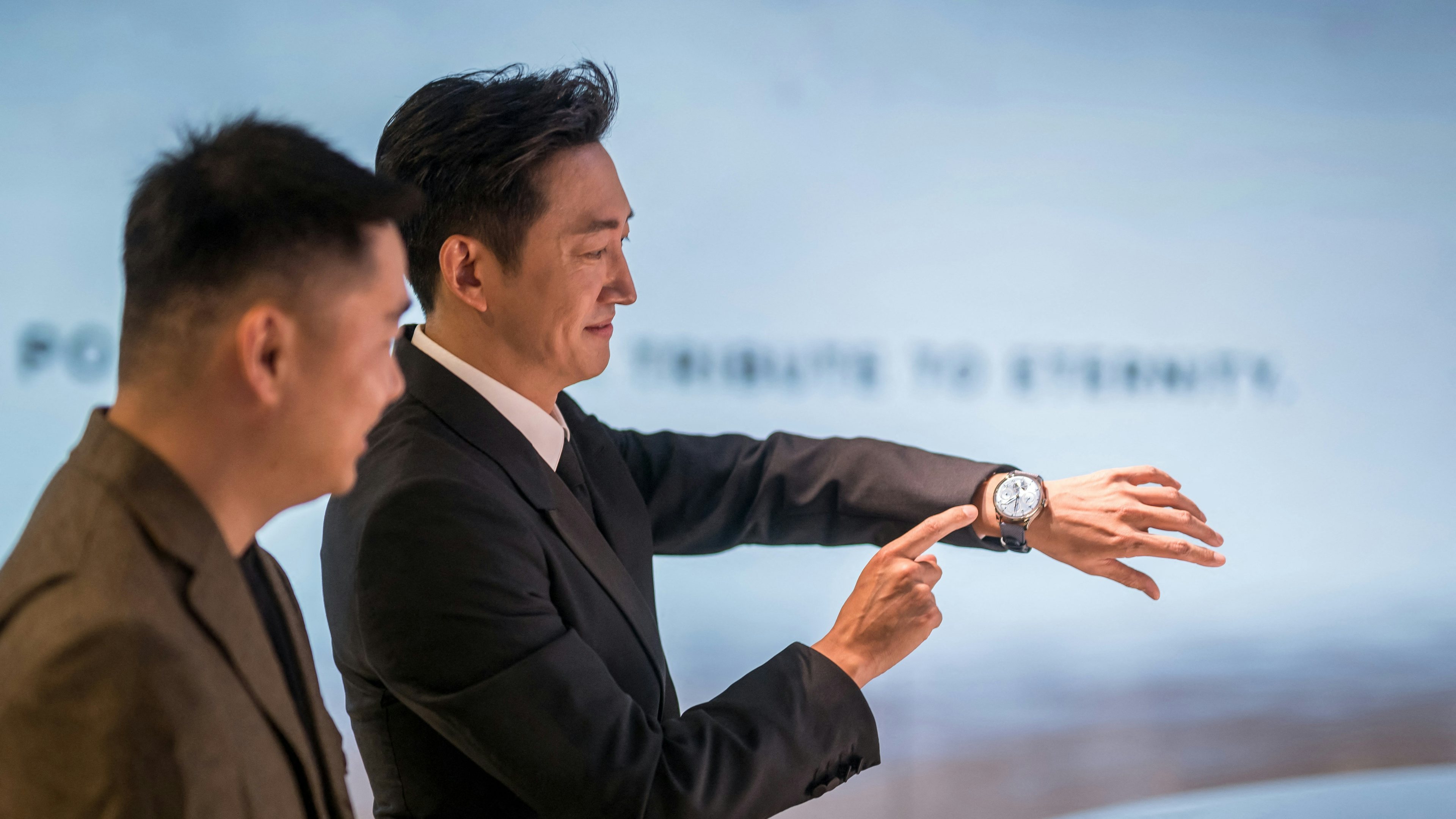 Chinese actor Wang Yang gestures to his watch during the opening day of Watches and Wonders Geneva 2024. Image: Getty Images