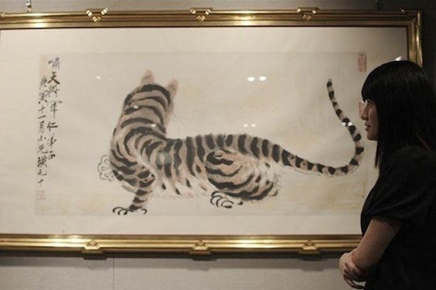 A woman looks at a painting entitled 'Tiger' by famed Chinese artist Qi Baishi in Hong Kong in 2010