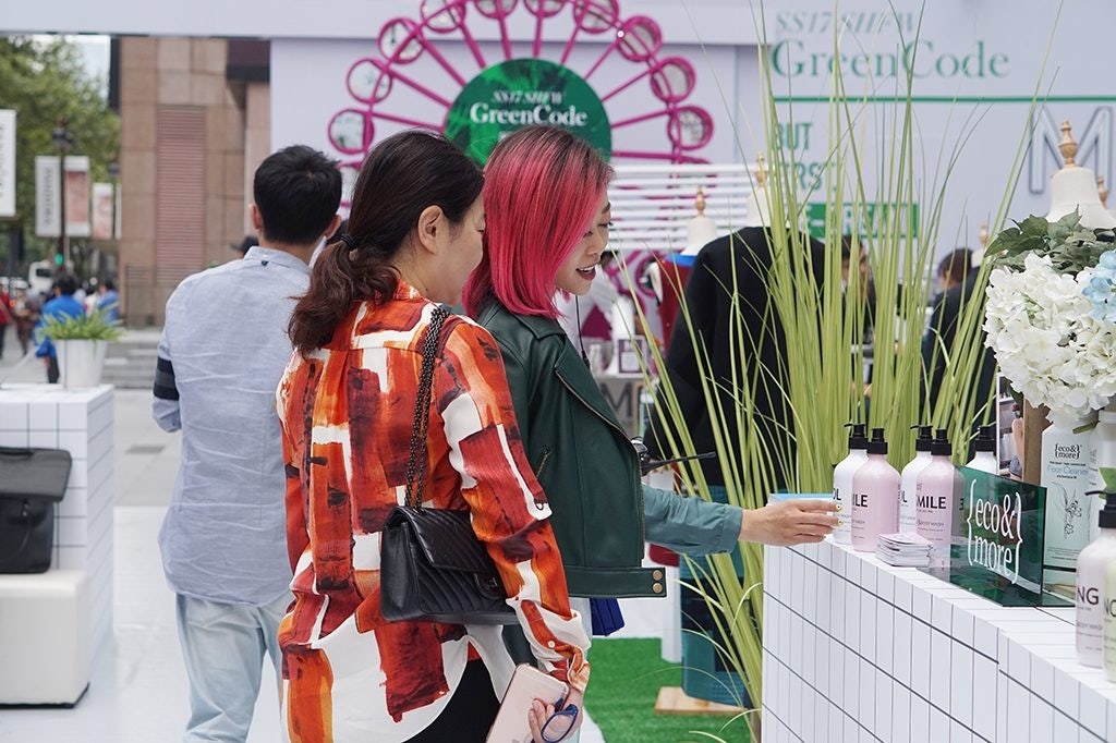 Candy Li (right) shows a shopper plant-based body care brand Eco & More. (Courtesy Photo)