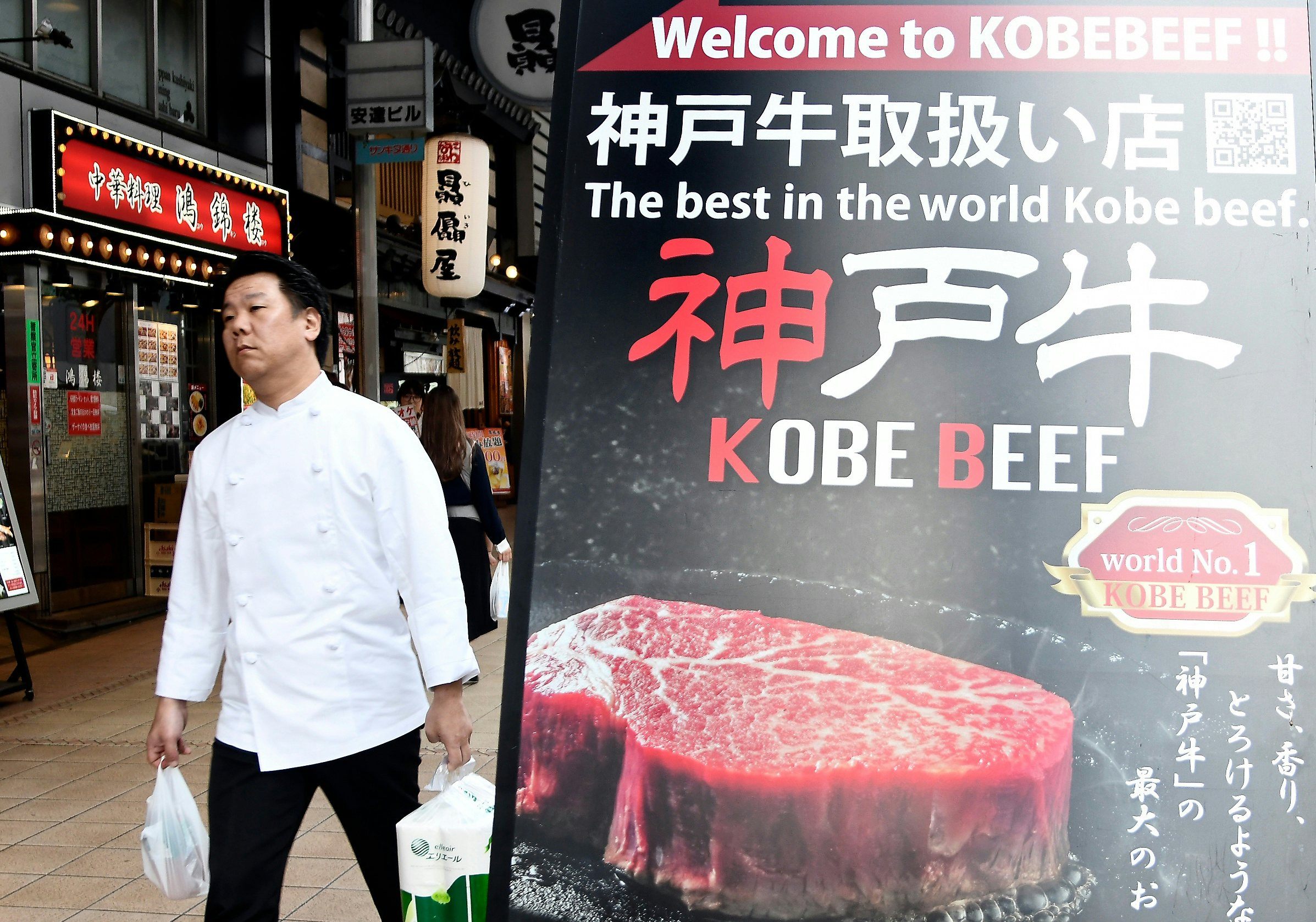 A man walk past a poster advertising Kobe beef in the center of Kobe on September 23, 2019. Photo: Ghetty Images