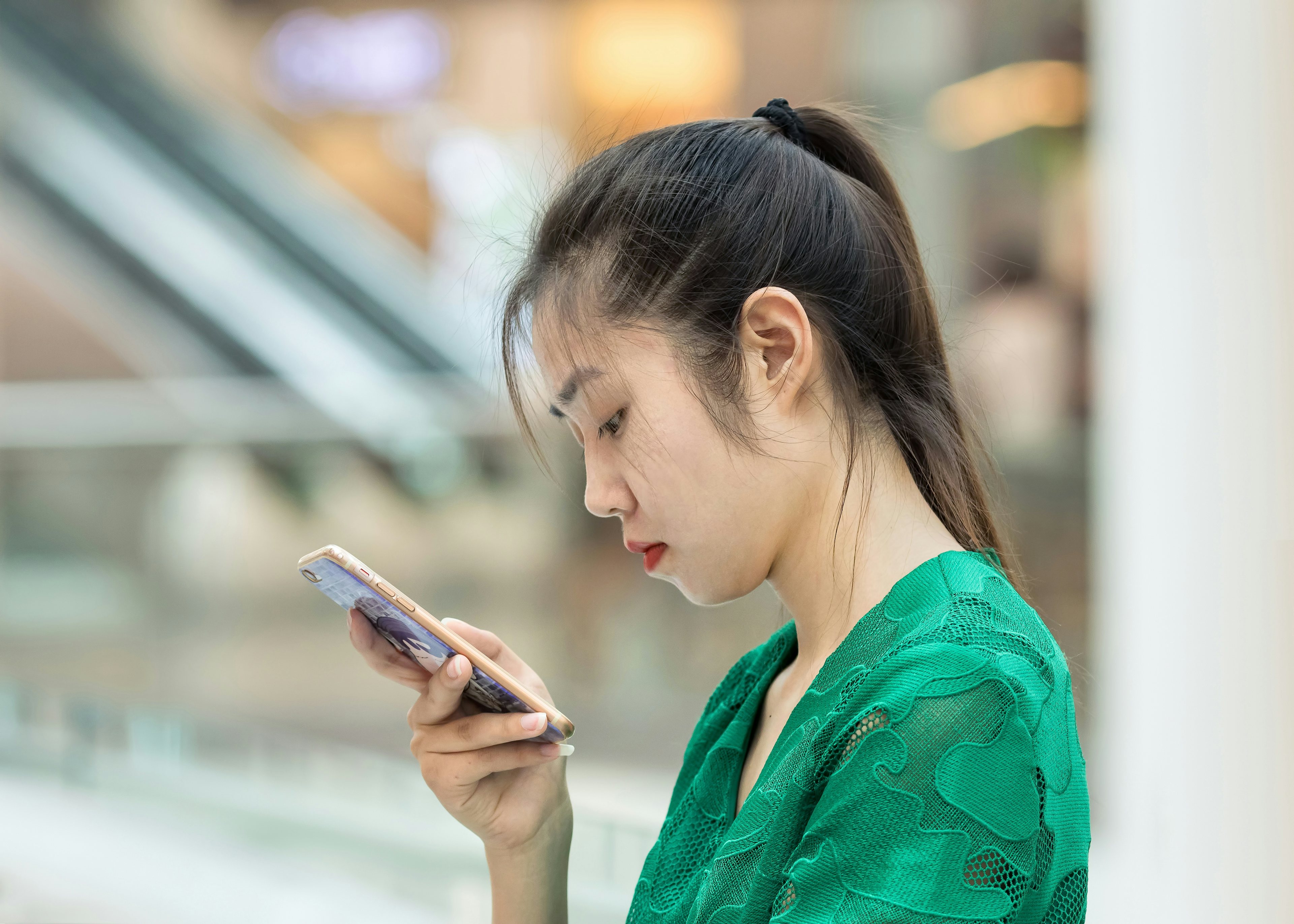 A girl looks at her smartphone in Beijing. (Shutterstock)