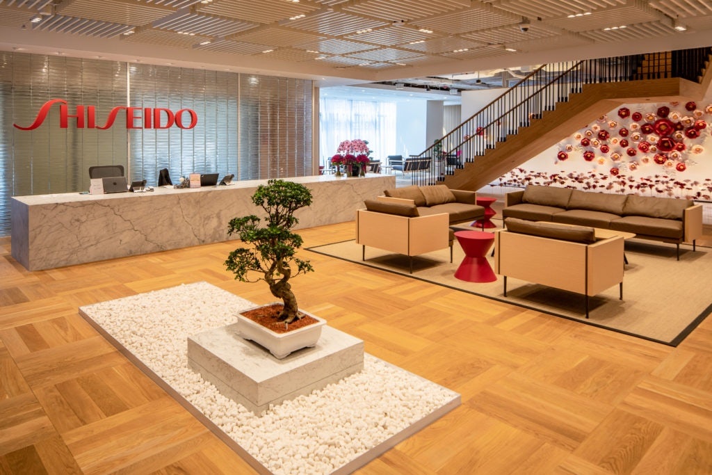 The welcoming reception area of Shiseido Travel Retail's new headquarter in Singapore. Note the minimalist design, open space and floral touches, including the striking installation of camellias and chrysanthemums at the staircase. Courtesy photo