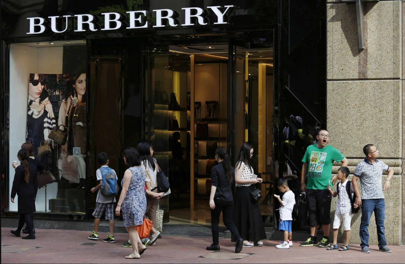 Shoppers wait outside a Burberry store in Causeway Bay. Luxury brands are going digital to attract millennial customers. Photo: Reuters