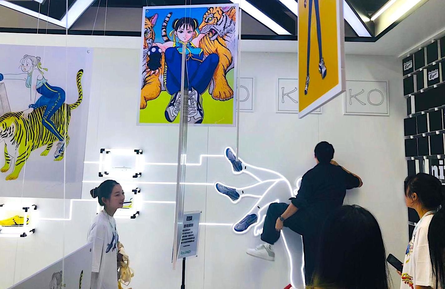 A visitor tries to imitate a high kick to win a gift bag at the Onitsuka Tiger booth. Photo: Ruonan Zheng/Jing Daily