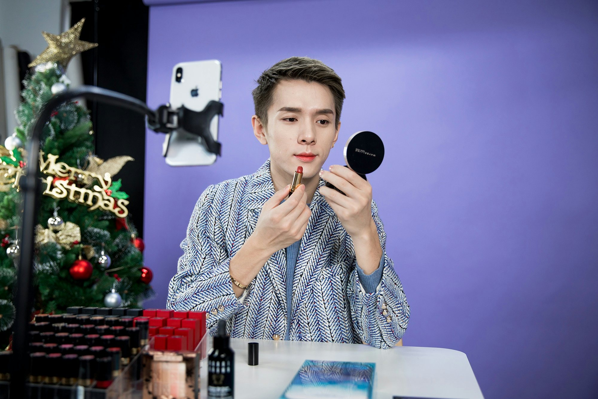 Beauty blogger Austin Li Jiaqi applies lipstick on his mouth while livestreaming on Taobao on January 3, 2018 in Shanghai. Photo: Ghetty Images