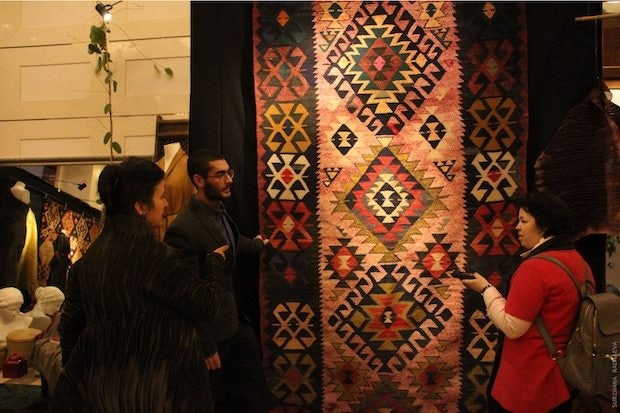 Zamani Collection Founder Matin Zaman discusses one of the nomadic Persian carpets on display at Four Seasons Beijing. (Surzhana Radnaeva)