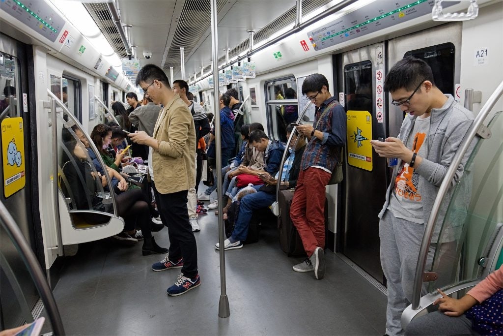 Chinese looking at their phones on the subway. Photo: Shutterstock.com