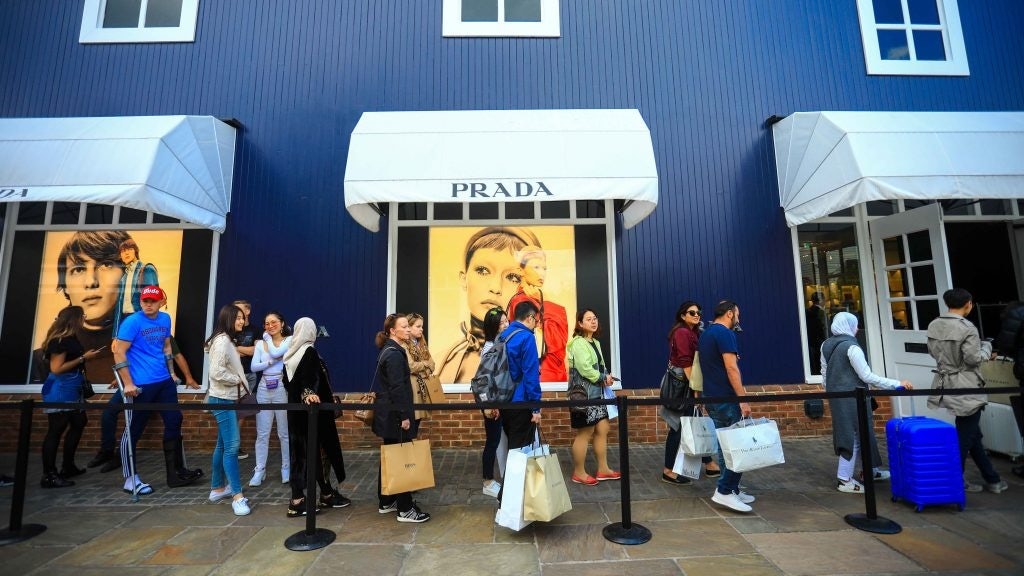 Shoppers line up outside of a Prada store in Bicester Village pre-pandemic. Photo: Shutterstock