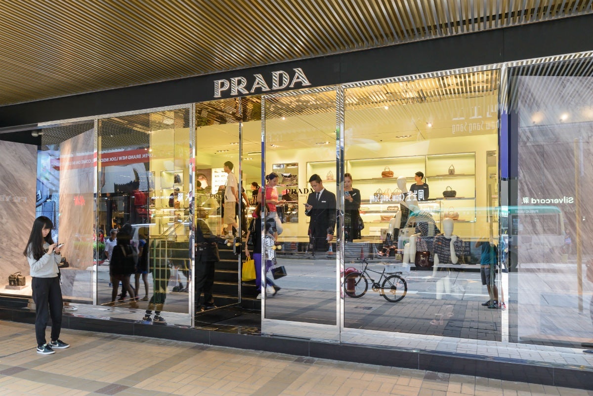 A Chinese shopper uses her phone outside a Prada store. Soon, luxury retailers in Europe will have the option to let Chinese shoppers at their brick-and-mortar stores pay for their items with their phone using WeChat. Photo: TungCheung / Shutterstock
