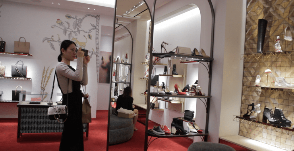 A student is taking pictures at the Christian Louboutin store.