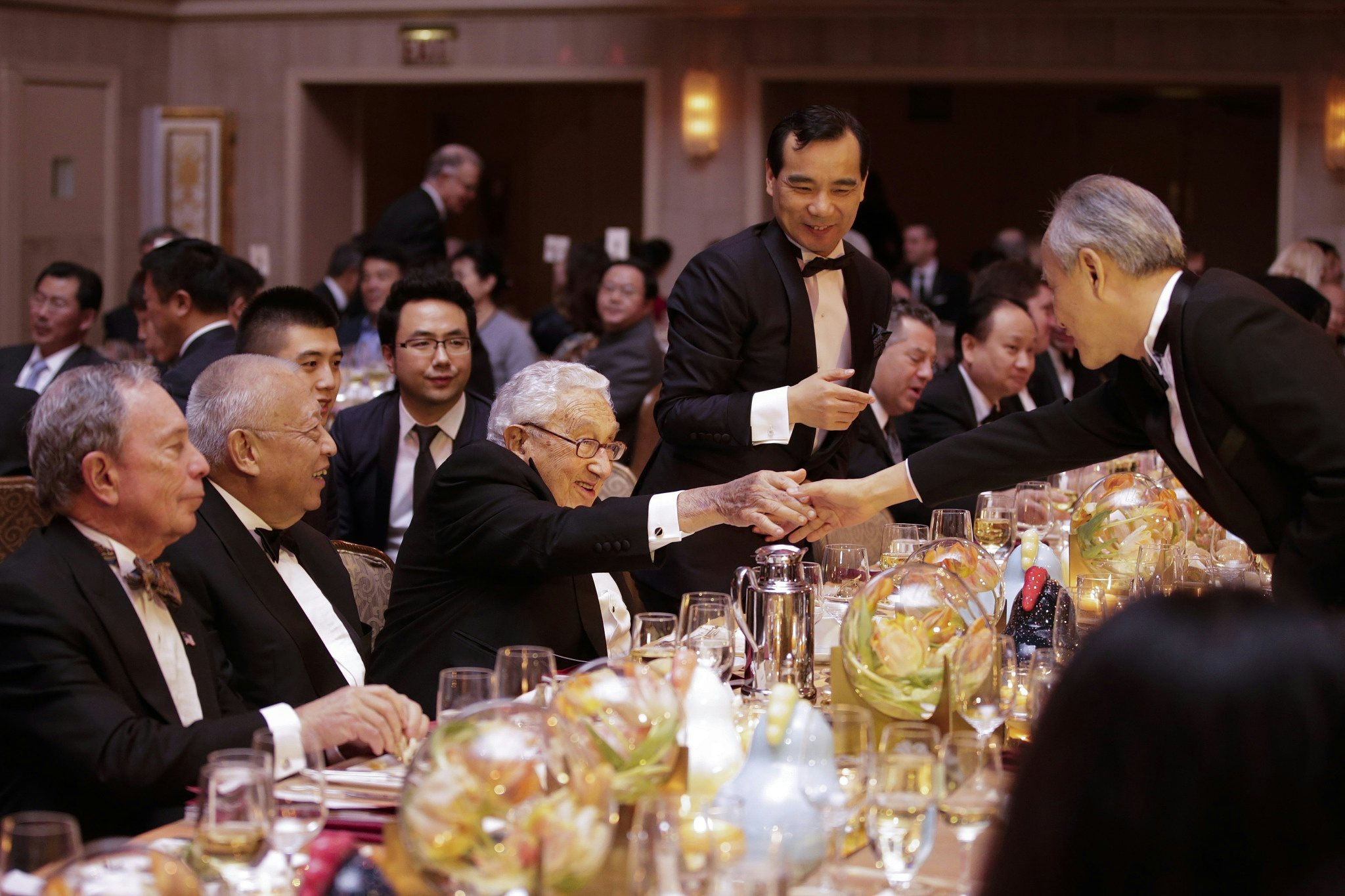 Wu Xiaohui in a dinner meeting with Michael Bloomberg (middle) and Henry Kissinger (right). Photo: VCG