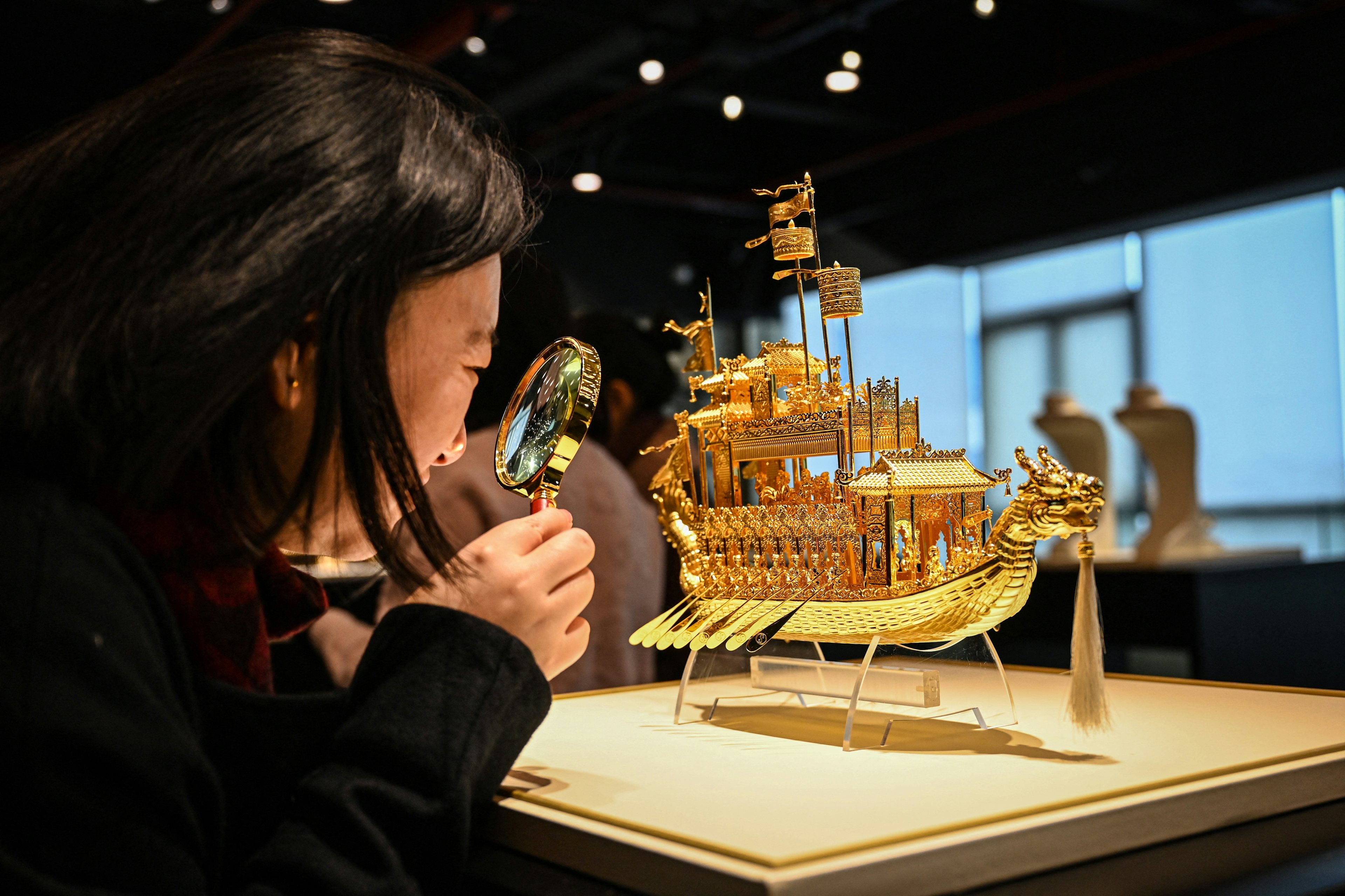 A woman observes details of a gold creation at a Chow Tai Fook jewelry store in Foshan, Guangdong province, on January 26, 2024. Photo: Ghetty Images